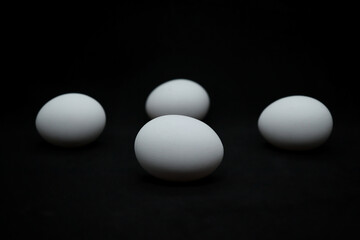 Chicken white eggs on a black tabletop