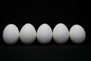 Chicken white eggs on a black tabletop