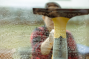 Woman using an electric window cleaner