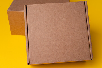 Fototapeta premium Beige cardboard boxes on yellow background, close up