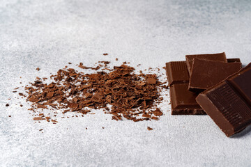 Grated chocolate and pieces of tasty chocolate on table