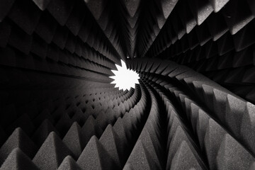 Roll of dark gray triangular acoustic foam rubber and light hole. The pattern of the soundproof panel of polyurethane foam. Shockproof foam. Selective focus.	 - obrazy, fototapety, plakaty