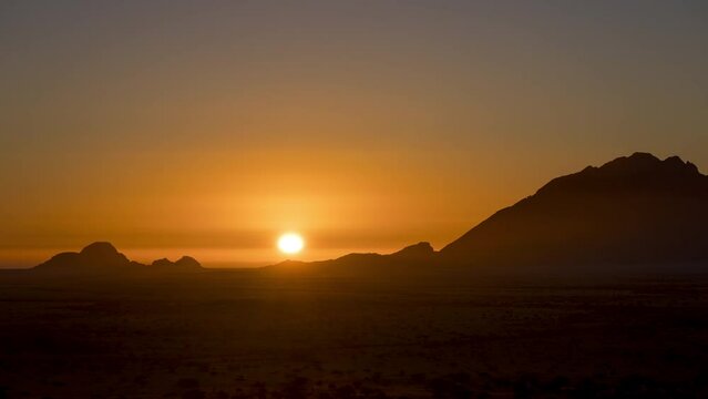 Beautiful Summer Sun Setting With Warm Colors Sky Behind Silhouetted Mountain Of Spitzkoppe In Namibia. - Wide Shot, Static