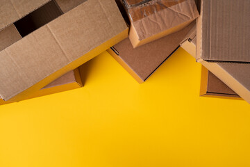 Beige cardboard boxes on yellow background, close up