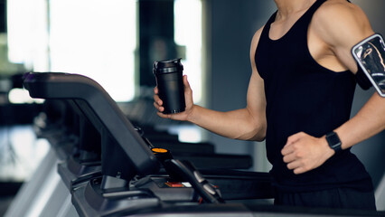 Fototapeta na wymiar Sporty Lifestyle. Unrecognizable Male Athlete Jogging On Treadmill At Modern Gym
