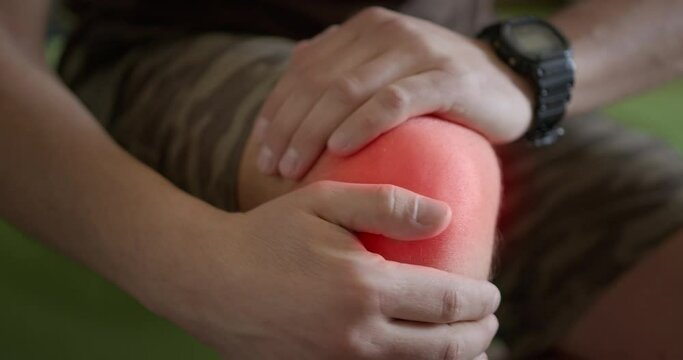 Close up shot of men with knee injury severe pain holding on his foot