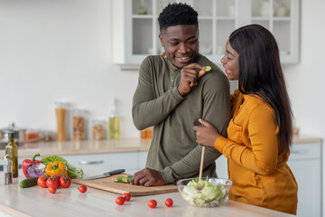 Loving african american couple preparing food in cozy kitchen together