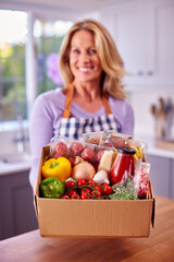 Portrait Of Mature Woman Unpacking Online Meal Food Recipe Kit Delivered To Home