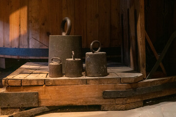 old metal weights on a antique wooden scale