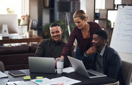 Meeting And Exceeding Expectations Together. Shot Of A Group Of Businesspeople Working Together On A Laptop In An Office.