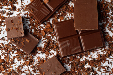 Grated chocolate and pieces of tasty chocolate on table