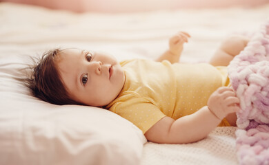 Obraz na płótnie Canvas Cute little baby lying under pink blanket.
