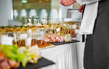 female hands of a waiter prepare food for a buffet table in a restaurant