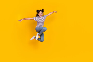 Full size photo of young cheerful pretty girl have fun jump up fly isolated over yellow color...