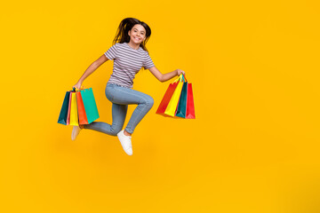 Full body profile side photo of young girl hold shopping bag run hurry isolated over yellow color background
