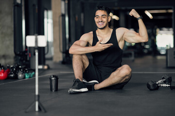 Fototapeta na wymiar Online Workouts. Handsome Arab Male Bodybuilder Recording Videos For His Fitness Blog