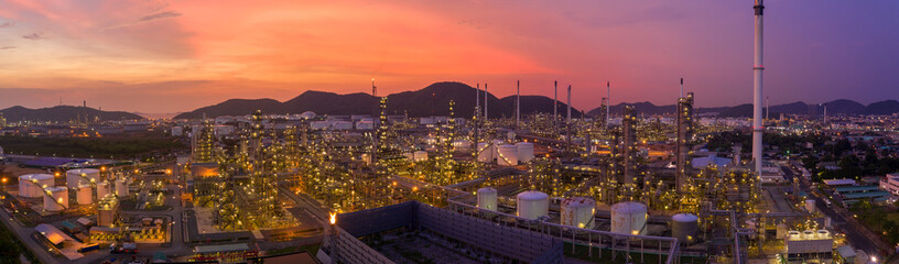 Aerial view. Oil refinery factory and oil storage tank at twilight and night. Banner panorama background	
