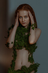 Beautiful red hair woman in moss portrait