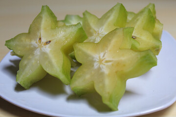 Carambola, or star fruit or 5 fingers, is the fruit of Averrhoa carambola. Green-yellow color. Cut in slices.