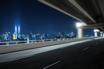 Motion blur effect highway overpass with city skyline background. Night scene .