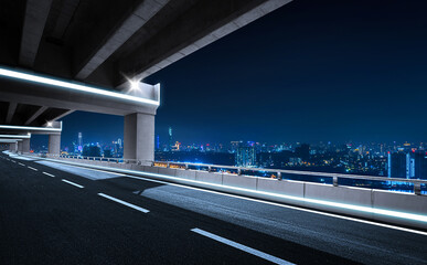 Fototapeta na wymiar Empty asphalt road during the night with beautiful city skyline background.