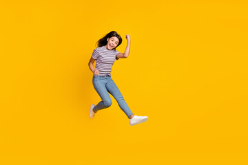 Fototapeta na wymiar Full size photo of young lady rejoice success fists hands triumph jump isolated over yellow color background