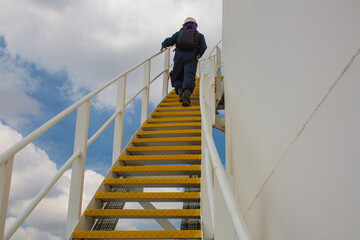 Male walking the up stairway inspection visual tank.