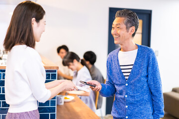 飲食店で電子マネー決済をする男性