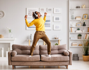 African American meloman dancing on couch