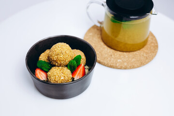 There are a bowl of dish of the cafe with some tea.