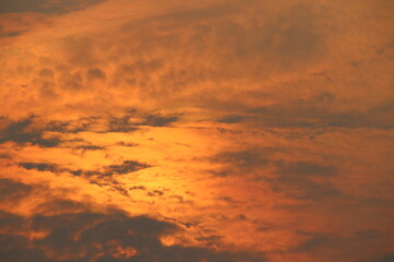 Sun light on fluffy clouds in evening sky and thin gray cloud cover some area background.