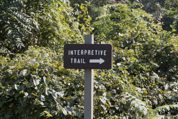 Sign of an interpretive trail near green bushes