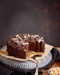 Healthy chocolate cake with almonds non sugar on a plate on the old wooden background. Selective focus. Keto diet.