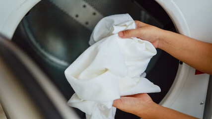 House husband with Basket and dirty laundry washed clothing in laundry room interior. washing machine at laundry business store