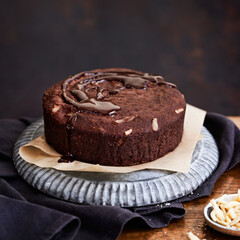 Healthy chocolate cake with almonds non sugar on a plate on the old wooden background. Selective focus. Keto diet.