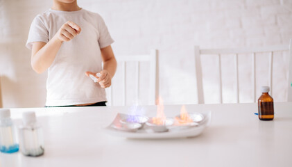 small children are experimenting. the boy looks at the experiment of multi-colored fire. Early development of children. Research and development concept