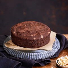 Healthy chocolate cake with almonds non sugar on a plate on the old wooden background. Selective focus. Keto diet.