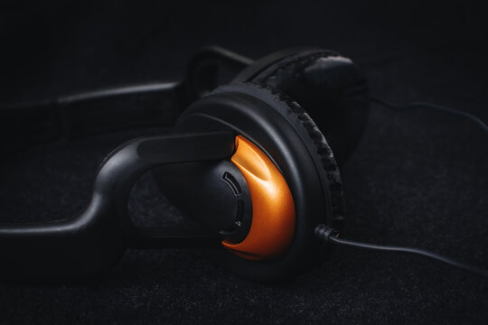 Black headphones on a dark background with soft light. An accessory for a musician.
