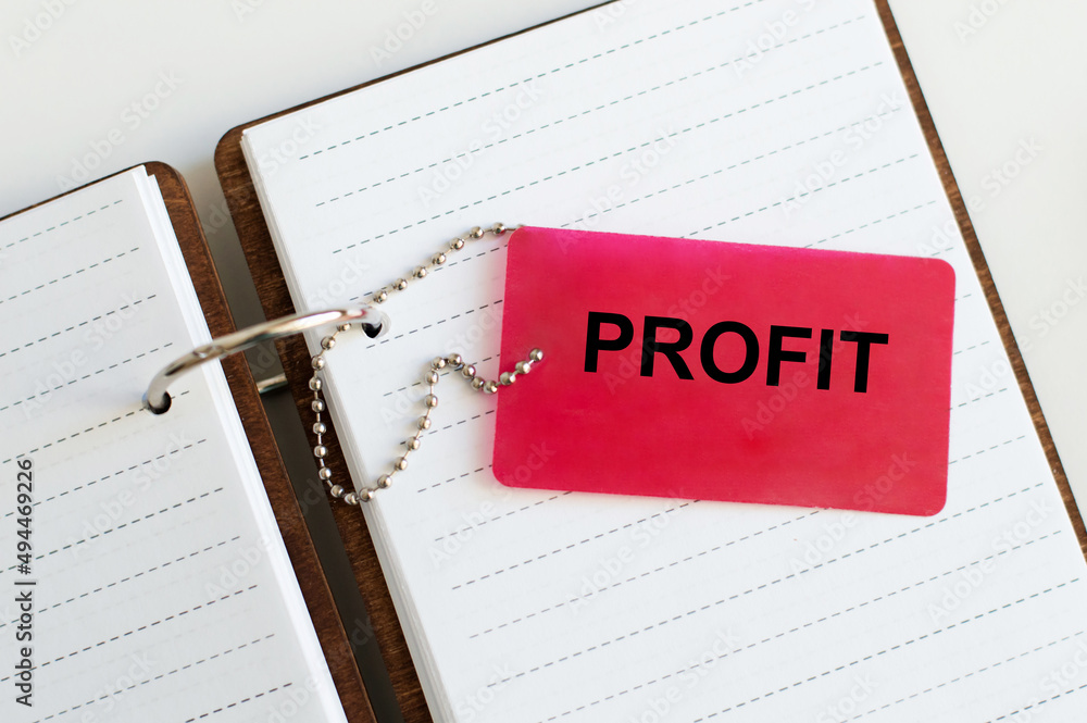 Poster profit text on the red tag on the chain on the notepad on the table
