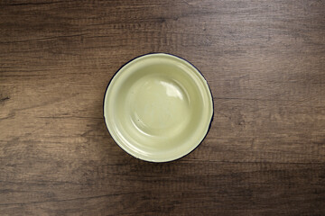 Enamel tin metal food plate pot bowl retro vintage tableware dinnerware on rustic wood background top view