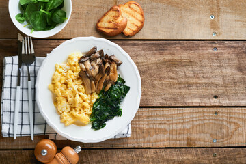 Omelet. Spinach oyster mushroom and cheese omelet or frittata on dark old wooden background. Breakfast idea. Top view with copy space.