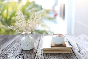 white cup with dry grass in a white vase