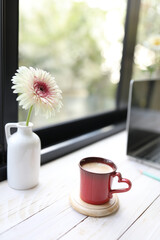 Red coffee cup and gerbera flower
