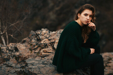 Fashionable young girl with messy hair in sweater outdoor