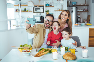 A young father and mother and child are in the kitchen, preparing a healthy meal together and...