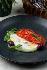 Delicious italian caprese salad with ripe tomatoes, fresh basil and mozzarella cheese, with copy space
