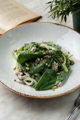 Wellness dinner, a portion of spinach and turkey breast salad on light marble kitchen table
