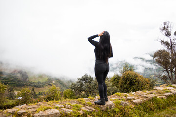 Hermosa foto de una mujer posando en la naturaleza sobre un fondo brumoso