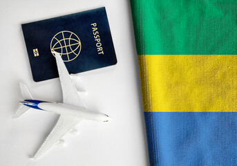 Flag of Gabon with passport and toy airplane. Flight travel concept
