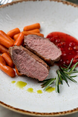 Confit duck breast with berry sauce, light beautiful commercial photo, close up, pink bloody cut